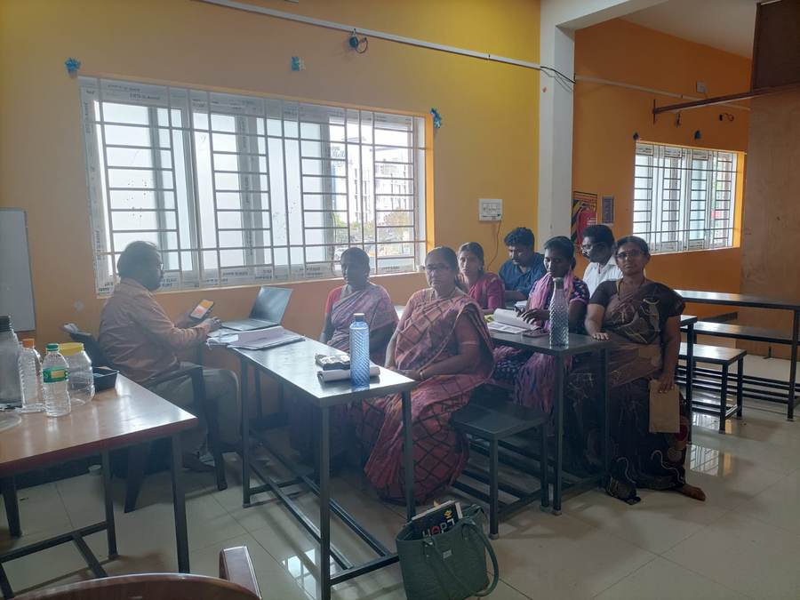 Women seated in a circle discussion, blue community room